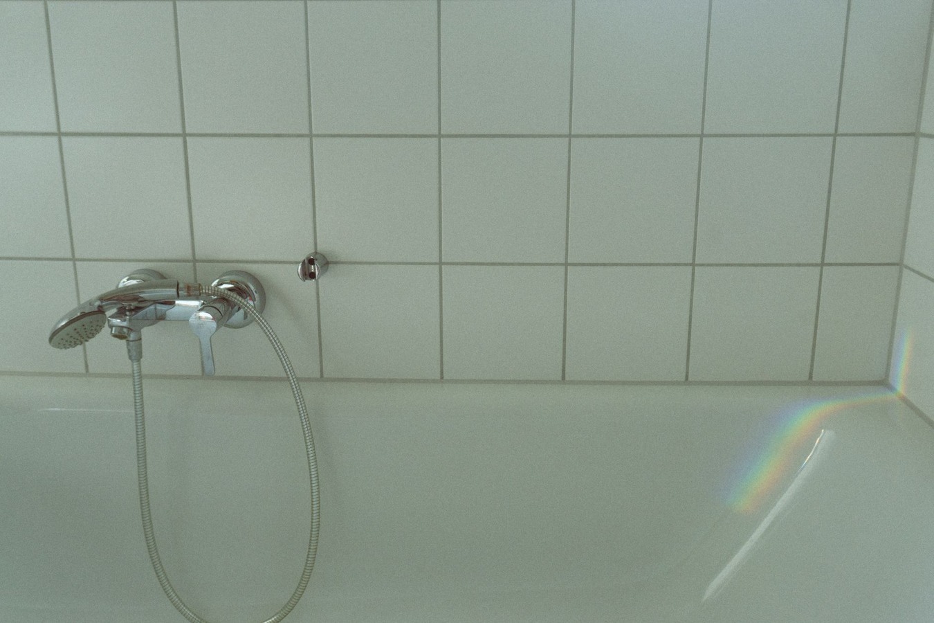 Before and after bathroom tile restoration showing grout transformation